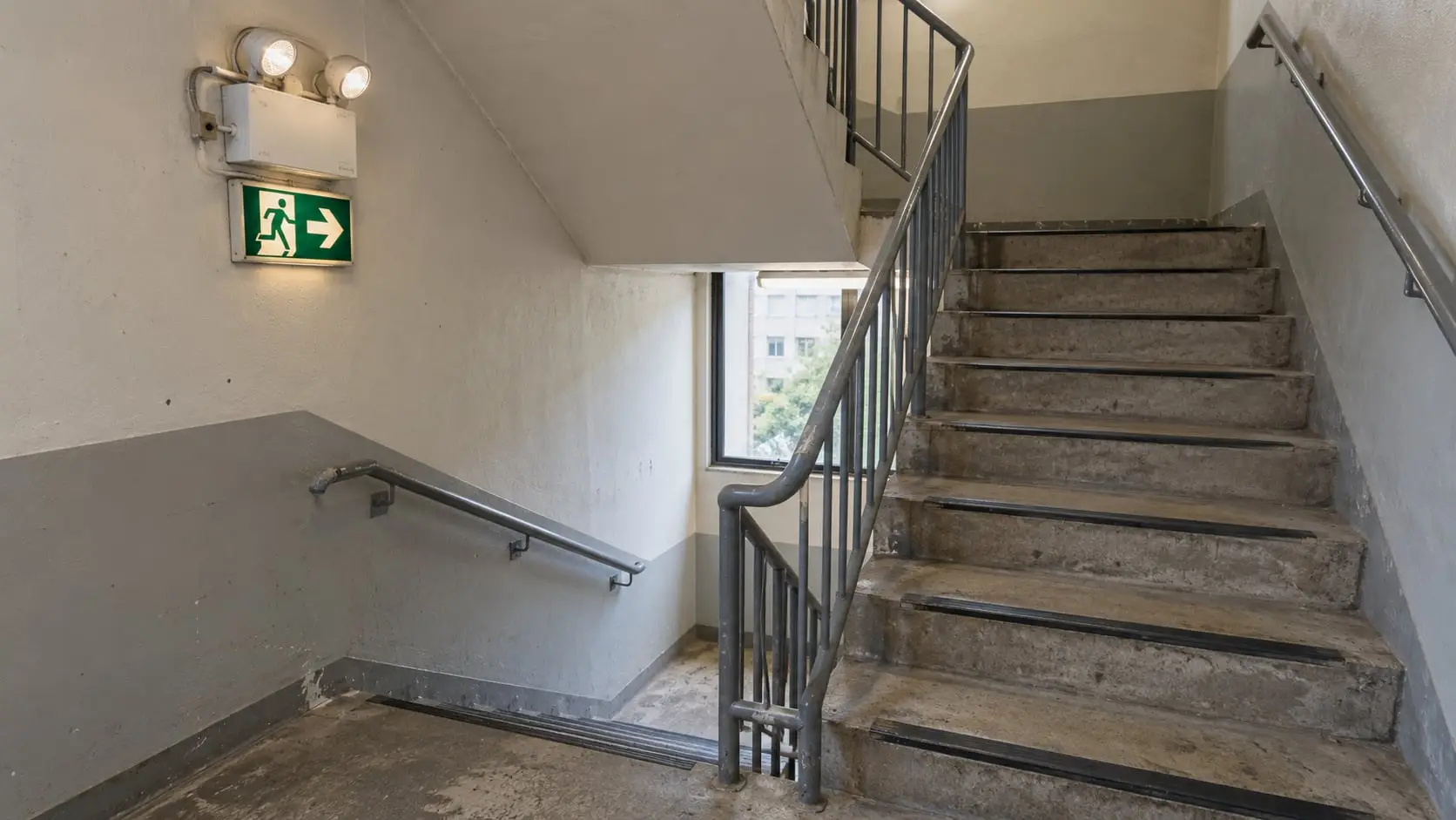 Emergency light and illuminated exit sign in a stairwell